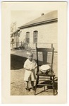 Unidentified boy beside chair with a birthday cake