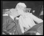 Bride and Groom kissing in back of car